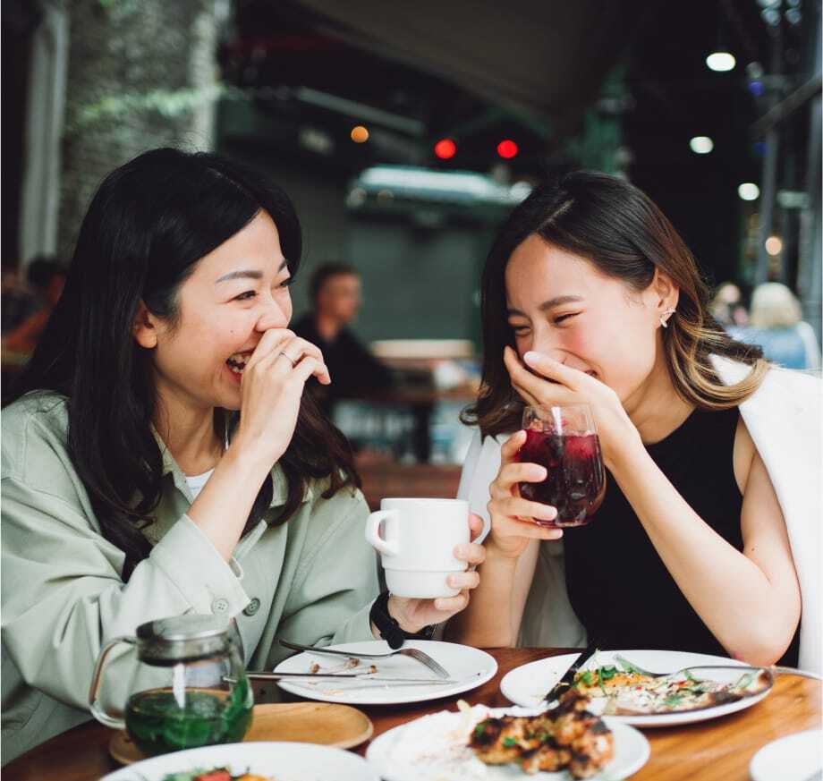 A mother and daughter having lunch and laughing