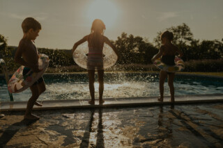 Children jumping in home pool.