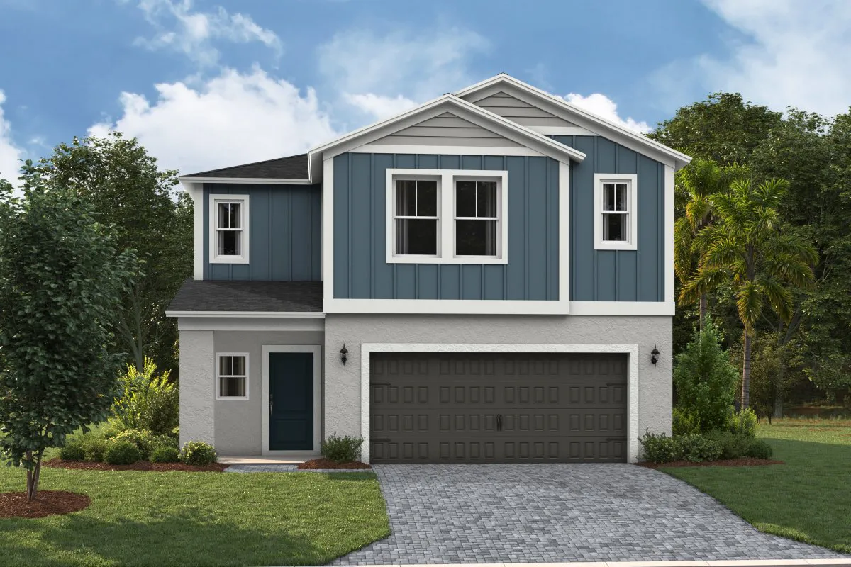 Two-story modern house with blue vertical siding on the upper level and light gray stucco on the lower level, featuring a dark garage door, small front porch, and landscaped yard with trees and bushes.