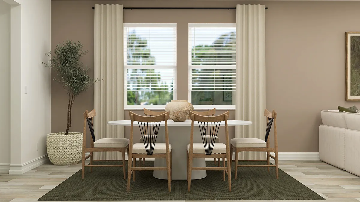 A modern dining room with a white oval table, six wooden chairs, a potted tree, cream curtains, and two large windows showing greenery outside. A neutral rug and wall art complete the cozy, minimalist decor.