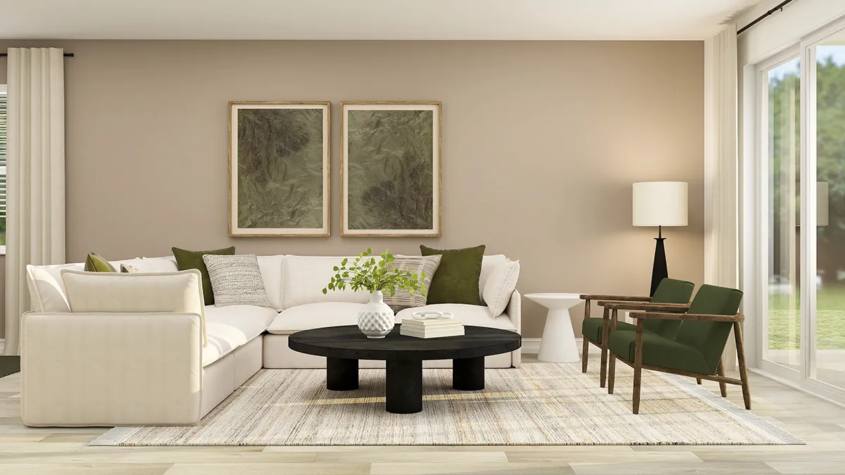 Modern living room with a beige sectional sofa, green and beige pillows, a black round coffee table, two green armchairs, a floor lamp, framed wall art, and large windows letting in natural light.
