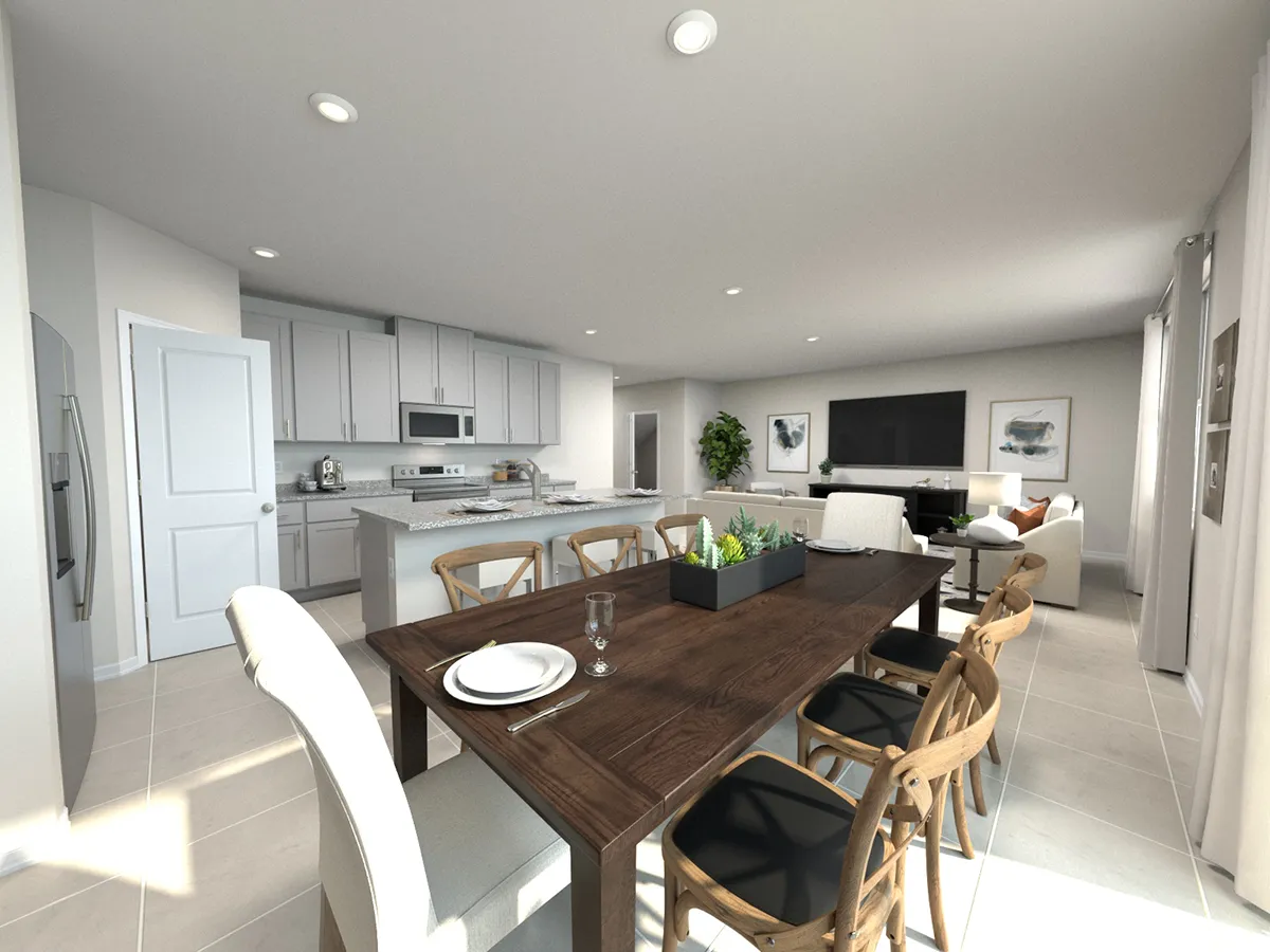 Modern open-concept kitchen and living room with white cabinets, stainless steel appliances, a dark wood dining table set for two, light wood chairs, and a TV in the living area. Neutral colors and natural lighting.