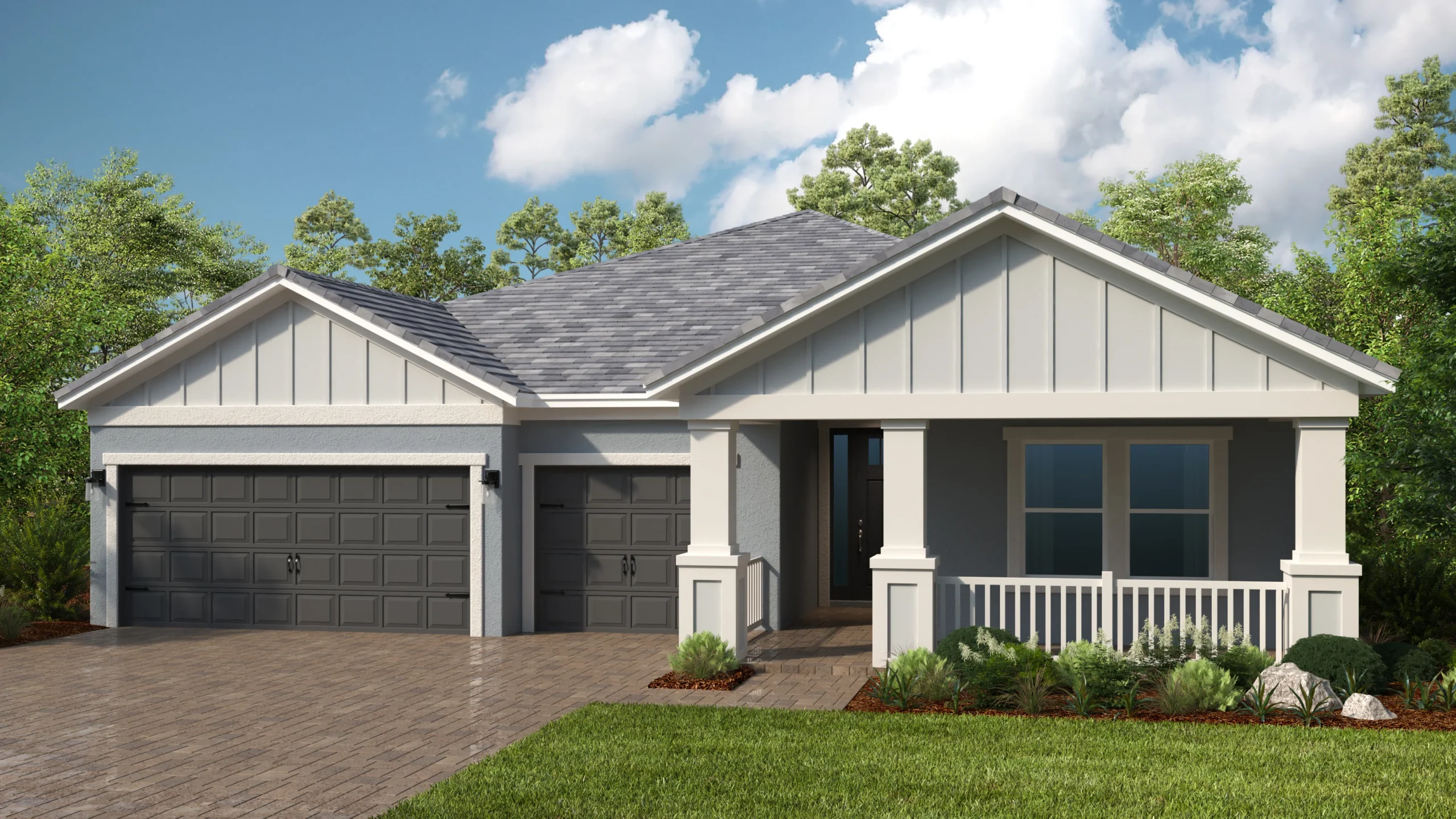 A modern single-story house with gray siding, a dark shingle roof, three-car garage, white columns, a small front porch with a railing, and well-kept landscaping, set against a backdrop of trees and blue sky.