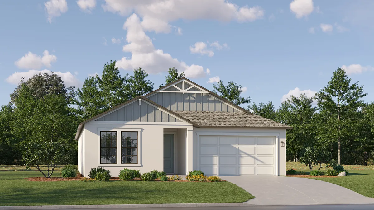 Single-story house with light-colored exterior, double garage, gable roof, three front windows, small front porch, and landscaped yard with shrubs and trees in the background under a partly cloudy sky.