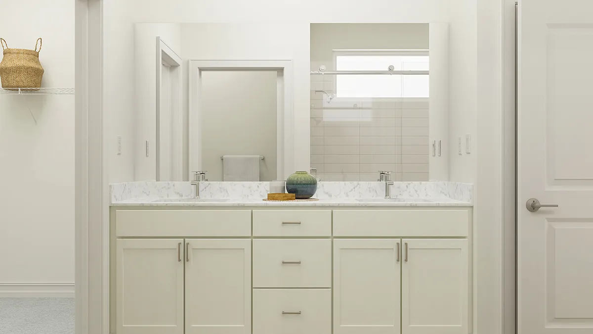 A modern bathroom with a double-sink vanity, white cabinets, marble countertop, and a decorative bowl in the center. There is a large mirror above the sinks and a shower area visible in the background.