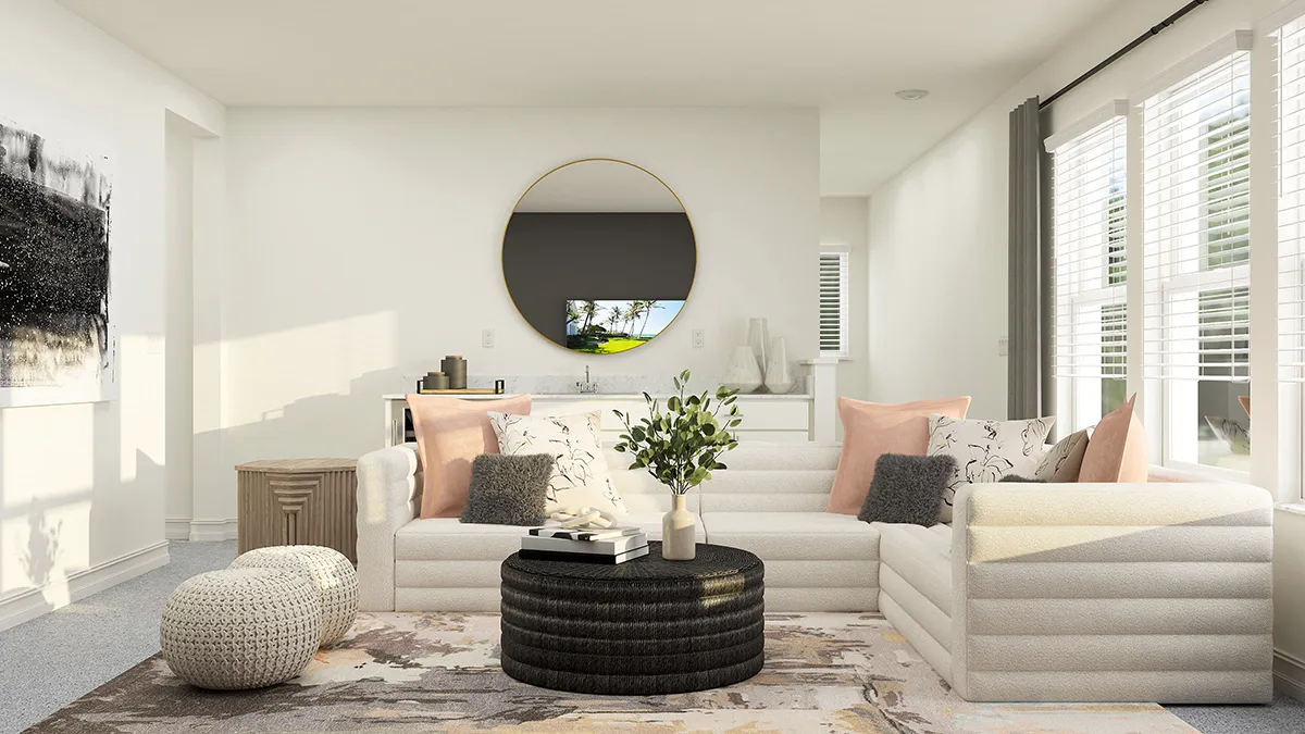 A bright, modern living room with a white sofa, pastel pillows, a round mirror above a sideboard, two poufs, a round black coffee table with a vase, large windows with blinds, and abstract art on the wall.