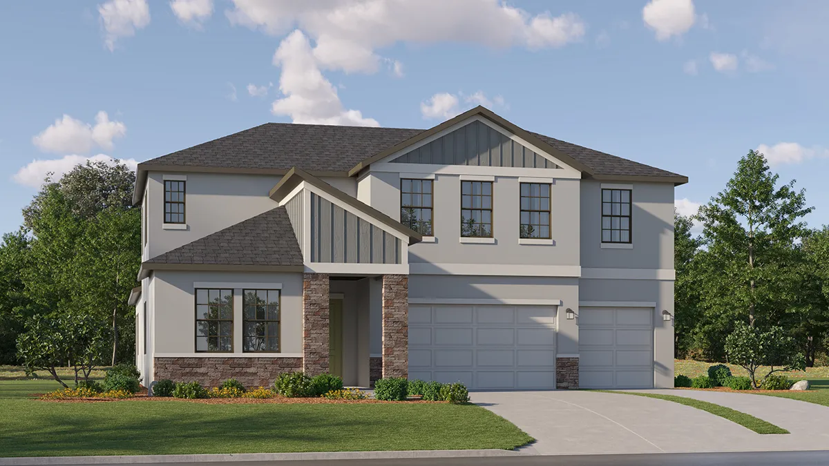 Two-story modern suburban house with gray siding, stone accents, and a dark shingle roof. The home has a three-car garage, large windows, and a well-maintained lawn with shrubs and trees in the background under a partly cloudy sky.