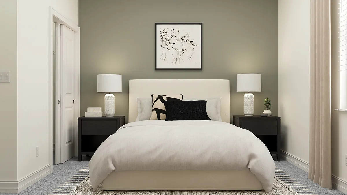 A modern bedroom with a beige bed, black and white pillows, two dark nightstands with white lamps, a small plant, and abstract art on an olive accent wall, lit by soft natural light from a window on the right.