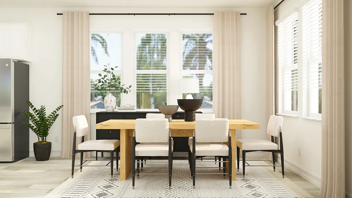 A modern dining room with a wooden table, eight cushioned chairs, a patterned rug, large windows with white blinds and beige curtains, plants, and decorative items on a black sideboard.