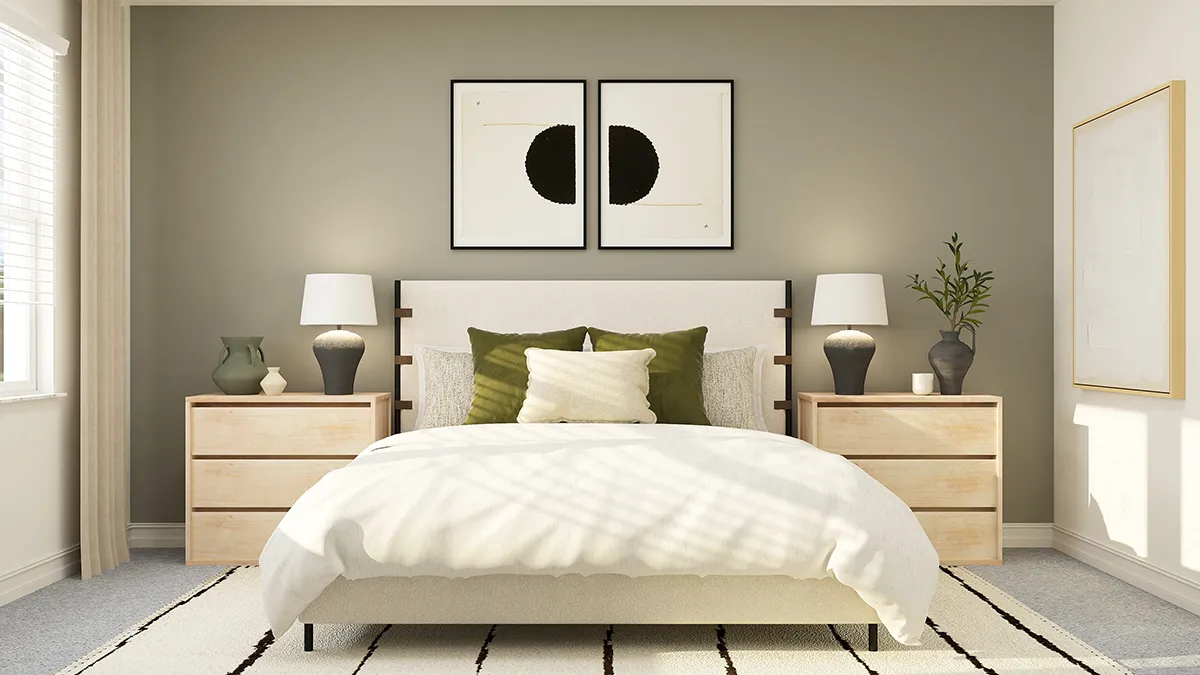 A modern bedroom with a neatly made bed, green and white pillows, two wooden nightstands with lamps, decorative vases, and minimalist art on a light olive accent wall. Sunlight streams through a window, casting shadows.